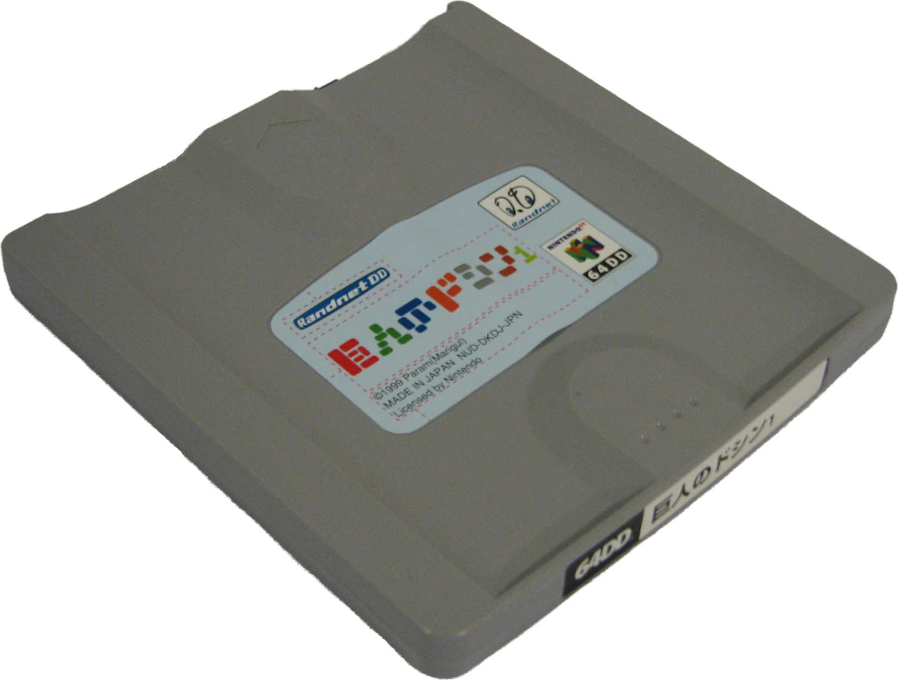 Une disquette magnétique grise de 64DD, au format carré, portant une étiquette japonaise en couleurs
