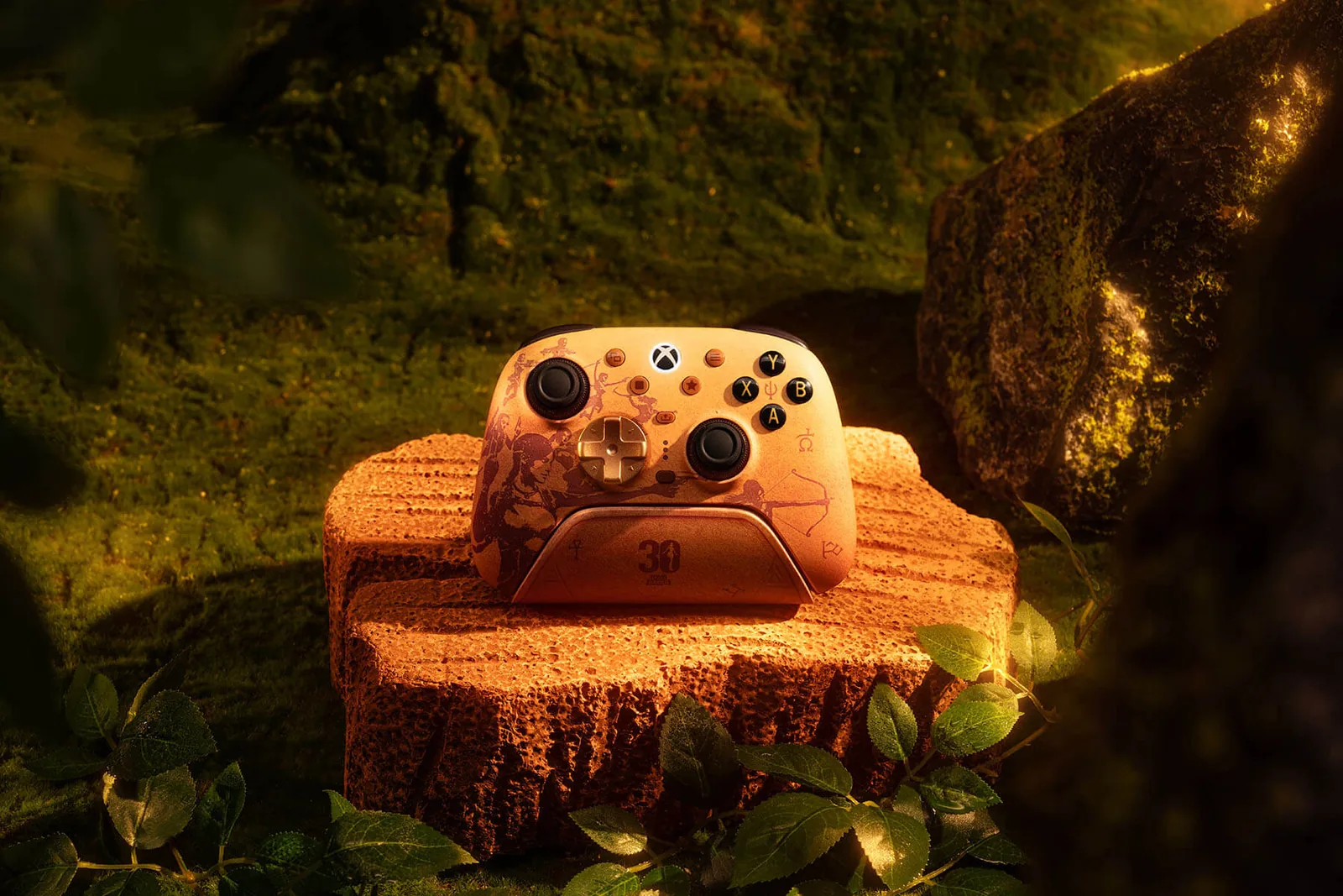 Visuel officiel : la manette Ultimate 3 pour Xbox, orangée, posée sur sa station de charge marquée 30, sur un socle de pierre. Des silhouettes de Lara Croft, dont une tendant un arc, sont gravées sur la coque