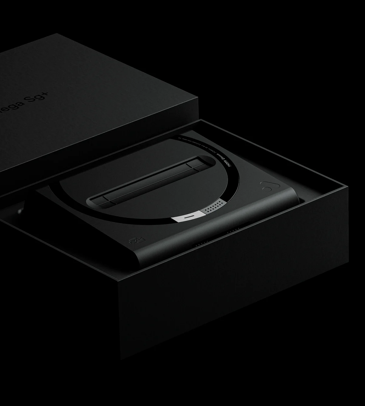 Une console Mega Sg+ noire dans sa boîte noire ouverte, le couvercle posé derrière