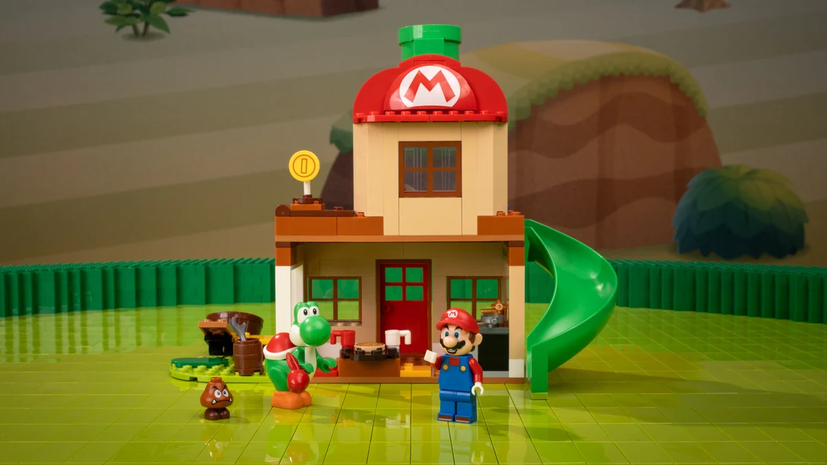 Le set Yoshi at Mario's House : la maison au toit champignon de Mario, le toboggan vert reliant l'étage au jardin, Yoshi et un Goomba en contrebas.