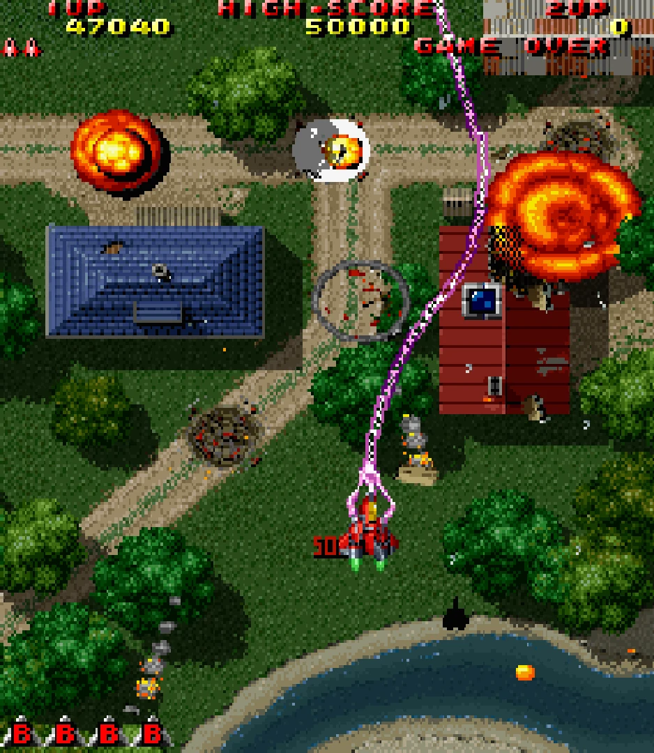 Capture verticale de Raiden Project : un chasseur rouge lance un rayon violet au milieu d'explosions, près de maisons au toit bleu et rouge