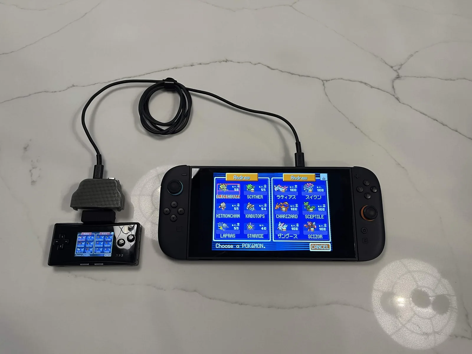 Photo officielle : une Game Boy Micro noire, l'adaptateur branché par l'intermédiaire d'une pièce noire, reliée par un câble à une Switch noire, les deux écrans sur le même menu d'échange
