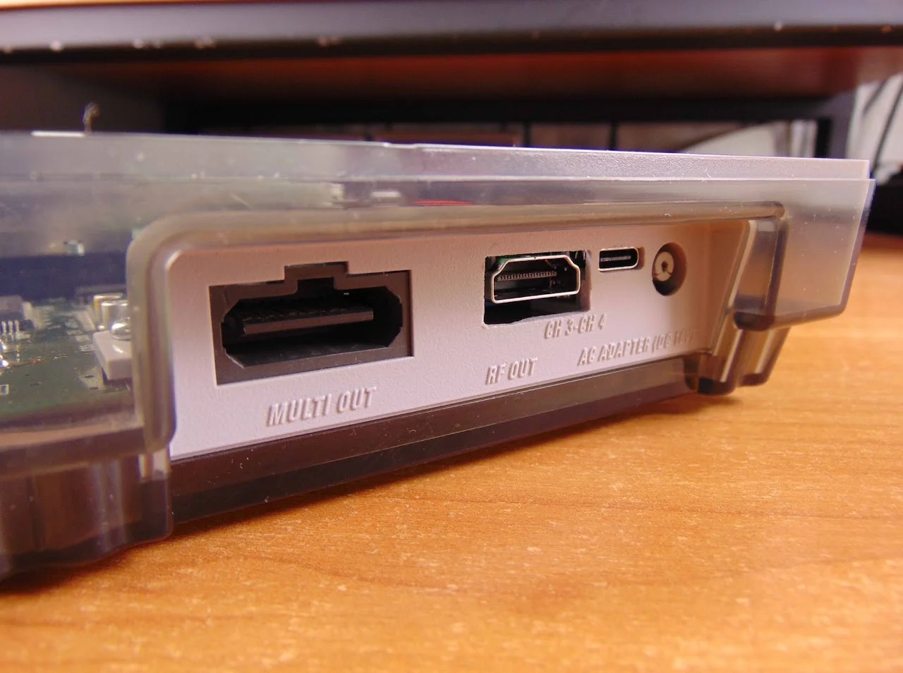Arrière d'une Super Nintendo : la prise MULTI OUT d'origine, puis une prise HDMI placée au-dessus des inscriptions CH 3-CH 4 et RF OUT, un port USB-C et la prise d'alimentation