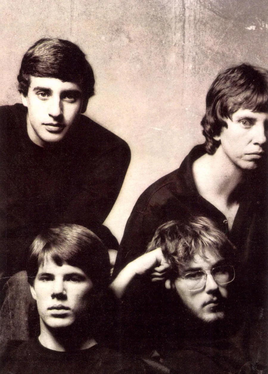 Quatre développeurs d'Electronic Arts photographiés en noir et blanc, posant comme un groupe de rock, sur le poster « We See Farther » de 1983.