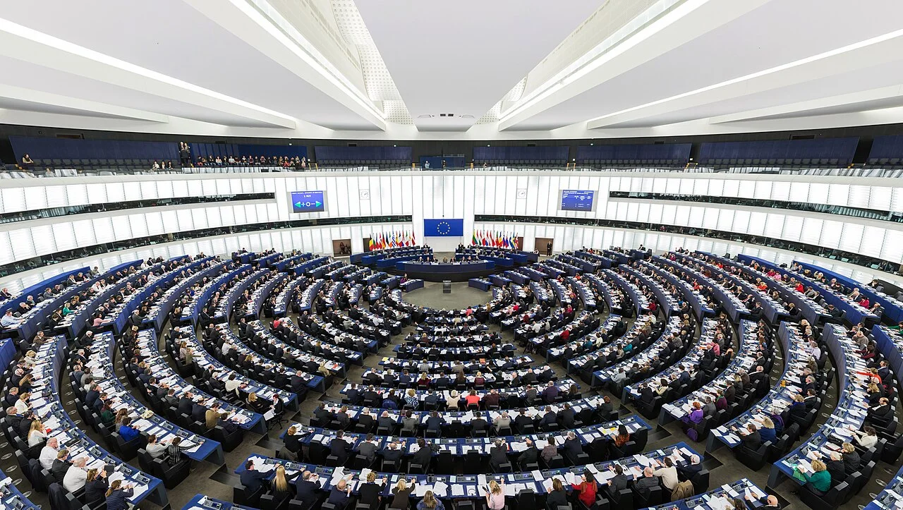 L'hémicycle du Parlement européen à Strasbourg, rangées de sièges bleus sous une verrière