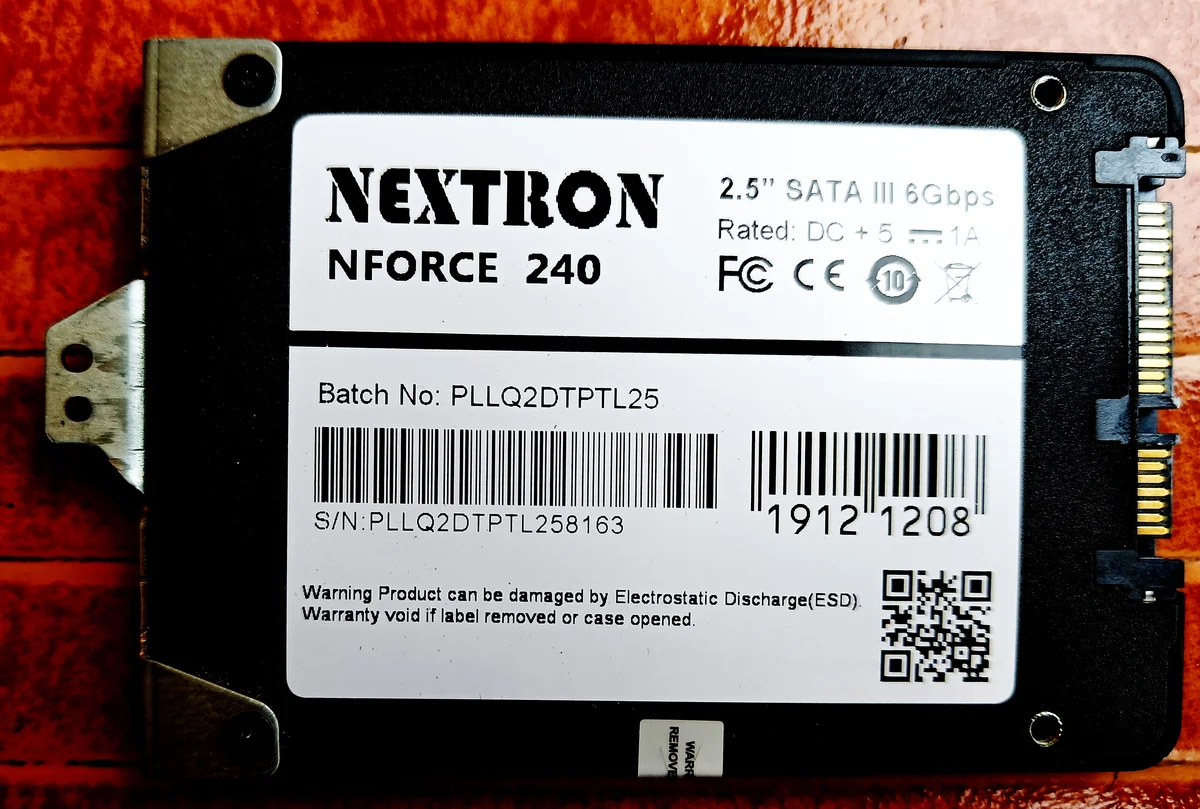 Un disque SSD au format SATA 2,5 pouces posé sur une surface claire