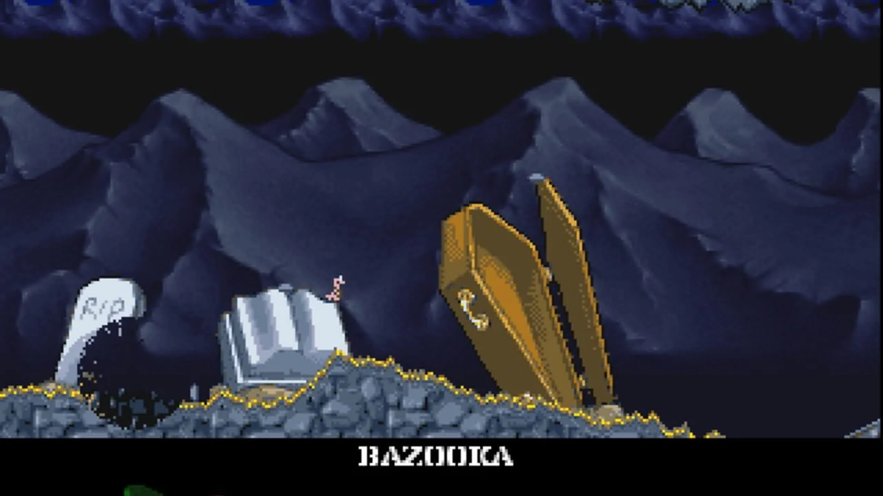 Niveau de cimetière dans Worms: The Director's Cut sur Amiga, avec un ver visant une arme Bazooka près de tombes et d'un cercueil